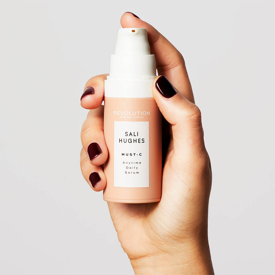 An image of a hand holding the Revolution Skincare x Sali Hughes Must-C Anytime Daily Serum